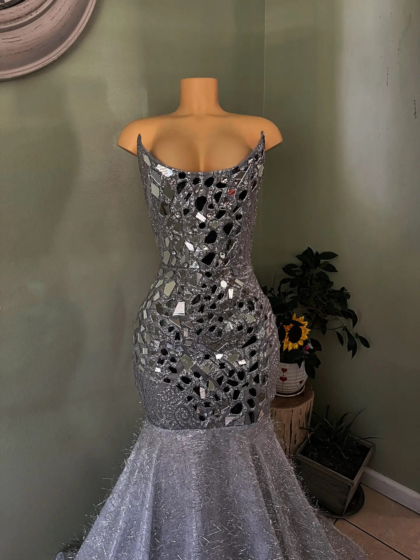 Silver mirror embellishment detailing Structured corset bodice Figure-enhancing mermaid silhouette Dramatic flared hem and train Glamorous reflective finish